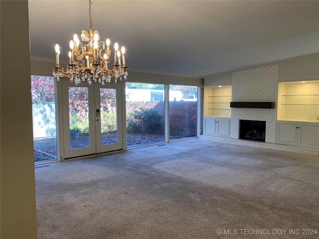 unfurnished living room with a fireplace, carpet, an inviting chandelier, and built in shelves