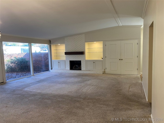 unfurnished living room with lofted ceiling, crown molding, built in features, a fireplace, and light colored carpet