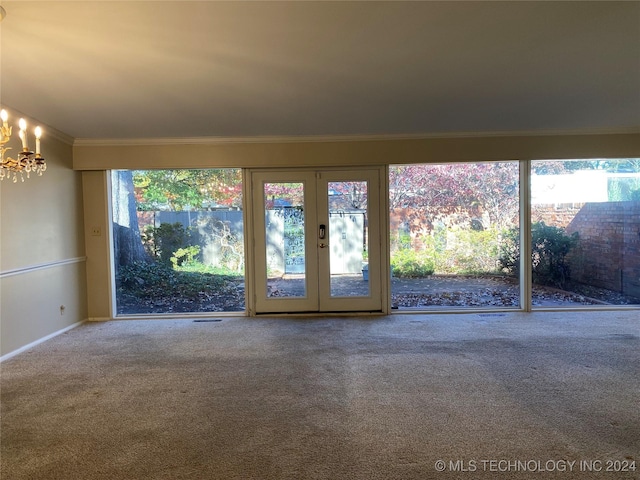 interior space featuring crown molding, french doors, and an inviting chandelier