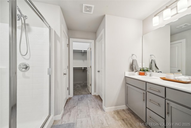 bathroom with vanity, wood-type flooring, and walk in shower