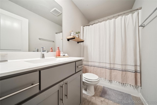 full bathroom with shower / bath combo, vanity, hardwood / wood-style flooring, and toilet