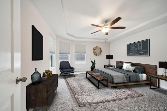 bedroom featuring a tray ceiling, ceiling fan, and carpet floors