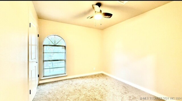 carpeted spare room featuring ceiling fan