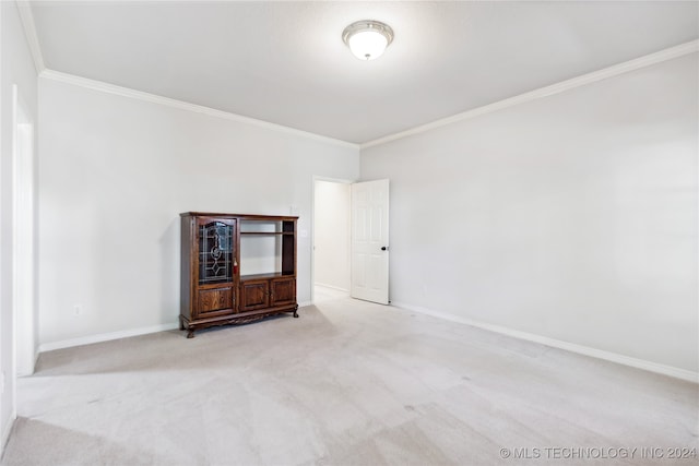 carpeted empty room featuring crown molding