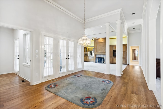 interior space featuring french doors, high vaulted ceiling, wood-type flooring, and ornamental molding