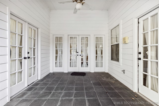 unfurnished sunroom featuring ceiling fan and french doors