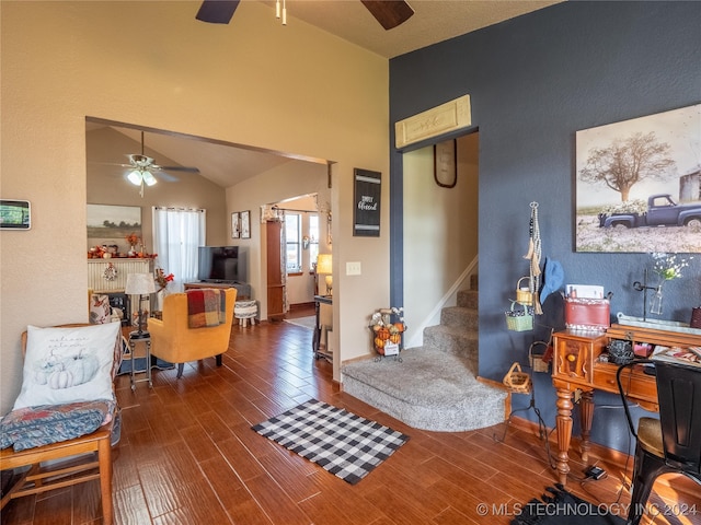 living room featuring dark wood-type flooring and vaulted ceiling