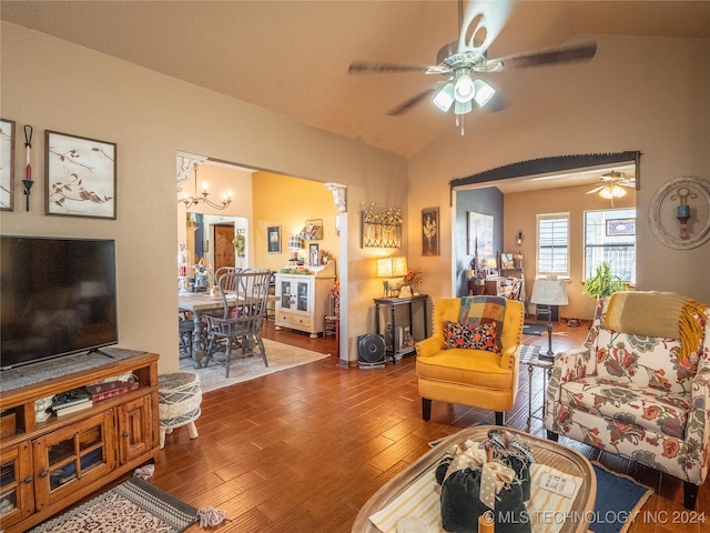 living room with hardwood / wood-style flooring, ceiling fan with notable chandelier, and vaulted ceiling