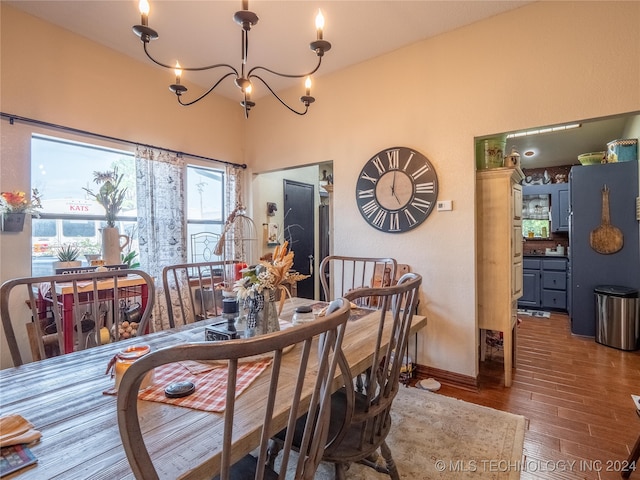 dining space featuring hardwood / wood-style floors and an inviting chandelier