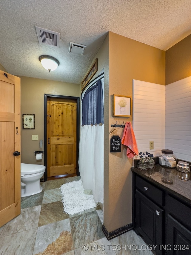 bathroom featuring a textured ceiling and toilet