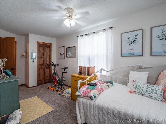 carpeted bedroom with ceiling fan, a closet, and a textured ceiling