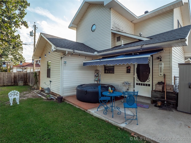 back of house with a patio area and a lawn