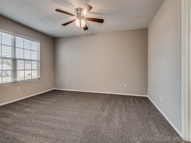 empty room with ceiling fan, carpet floors, and a textured ceiling