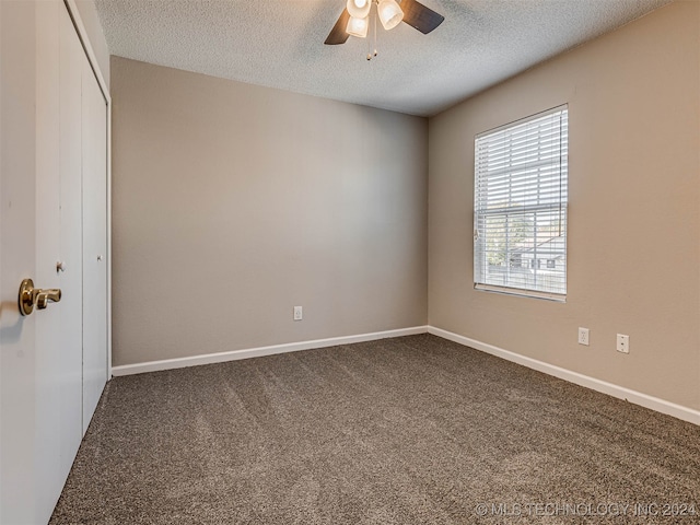 unfurnished room featuring ceiling fan, carpet floors, and a textured ceiling