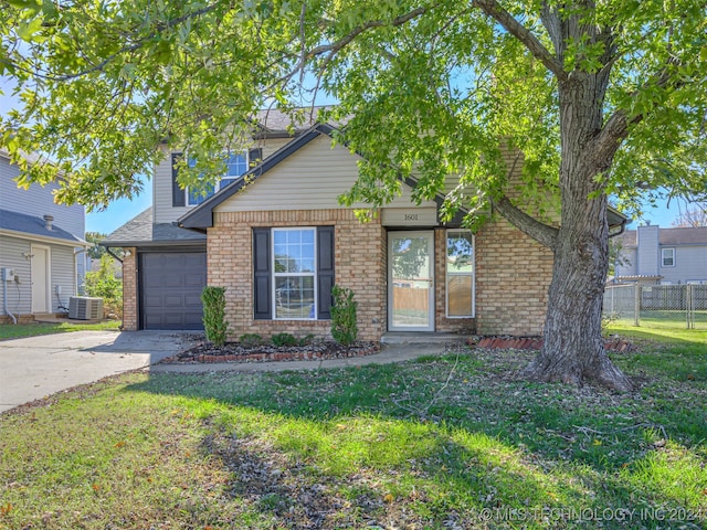 view of front of property featuring a front yard, a garage, and central air condition unit