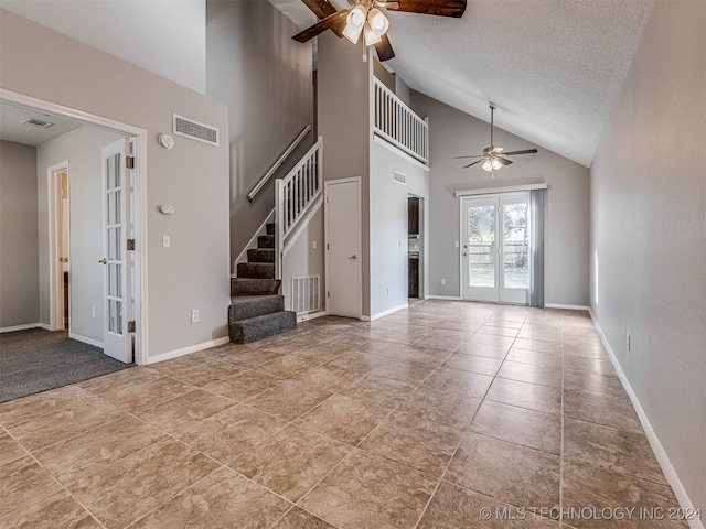 interior space featuring high vaulted ceiling, french doors, tile patterned flooring, ceiling fan, and a textured ceiling