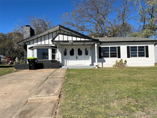 view of front of house featuring a front lawn, board and batten siding, and a chimney