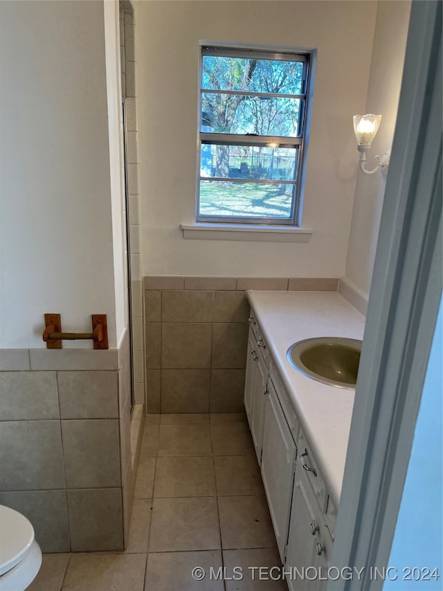 bathroom with tile patterned flooring, vanity, toilet, and an enclosed shower