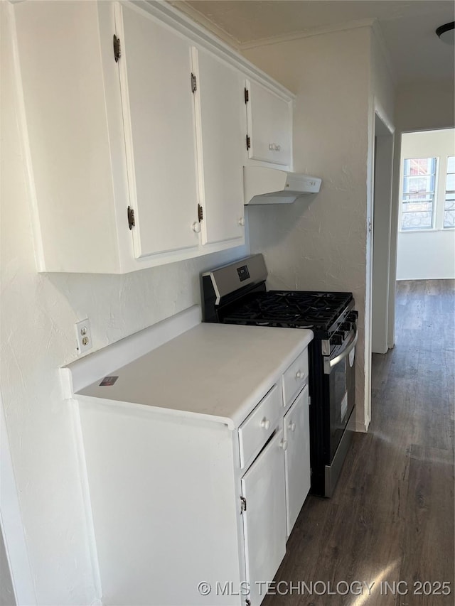 kitchen with dark wood-style floors, light countertops, white cabinets, stainless steel range with gas stovetop, and under cabinet range hood