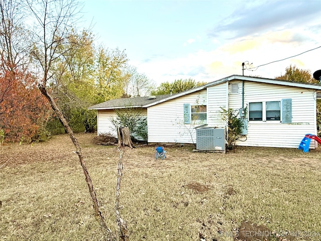 view of home's exterior featuring a lawn and central AC