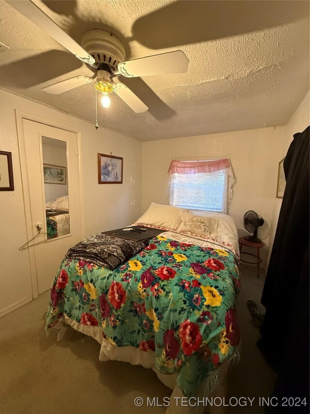 carpeted bedroom with a textured ceiling and ceiling fan