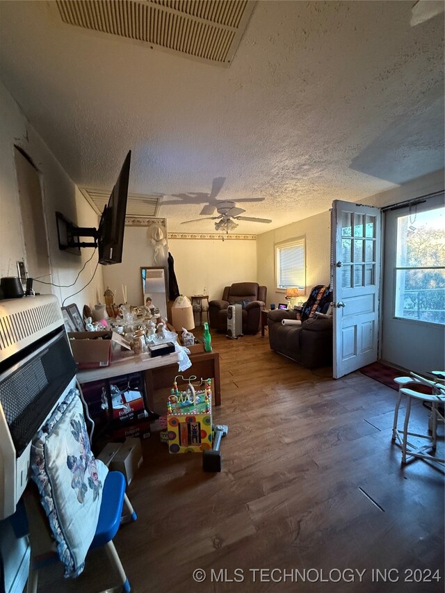 misc room with ceiling fan, wood-type flooring, and a textured ceiling