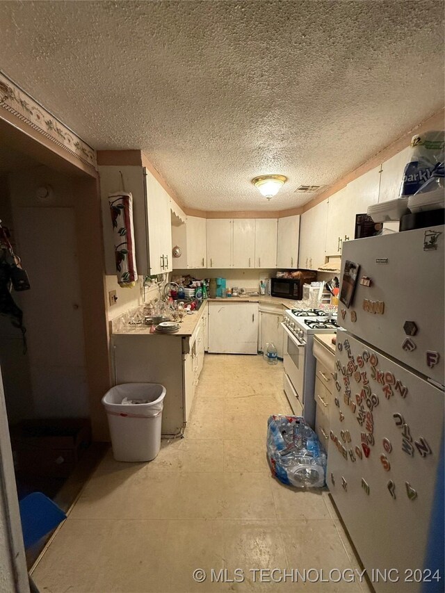 kitchen with a textured ceiling and white appliances