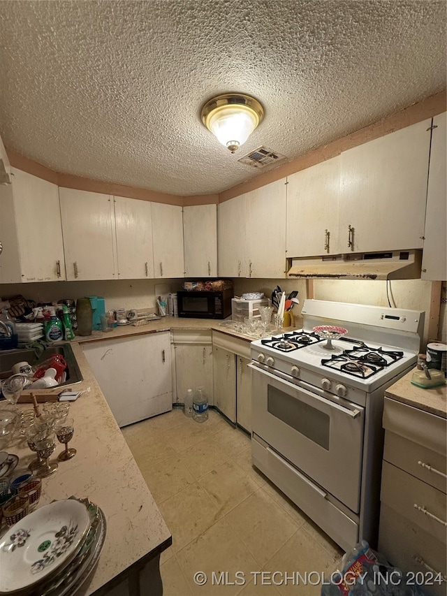 kitchen with white cabinetry, gas range gas stove, and a textured ceiling