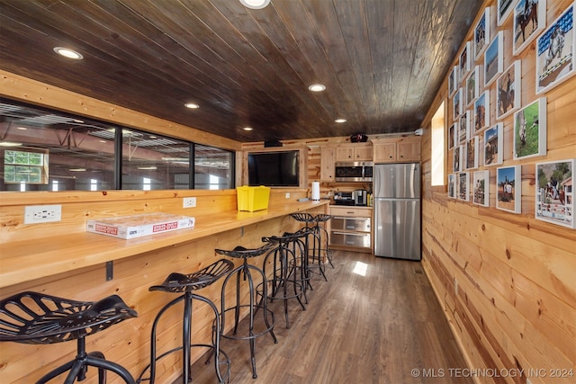 kitchen with dark wood-type flooring, stainless steel appliances, wood counters, wooden ceiling, and wooden walls