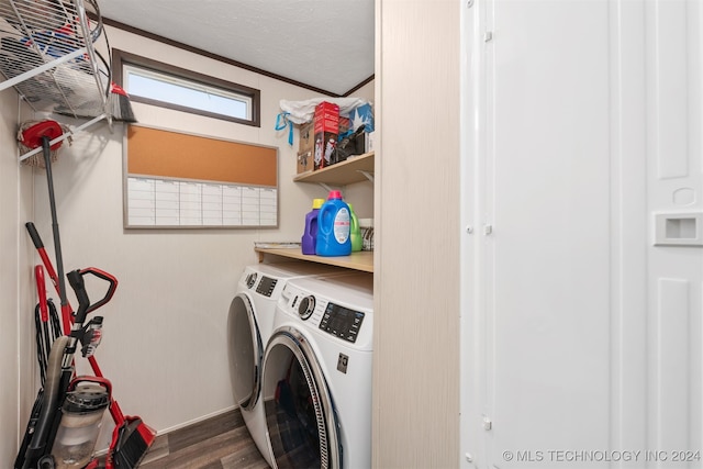 washroom featuring washing machine and clothes dryer, crown molding, dark wood-type flooring, and a textured ceiling