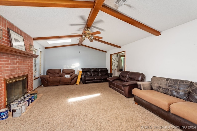 living room with carpet, vaulted ceiling with skylight, a textured ceiling, ceiling fan, and a fireplace