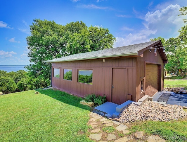 view of outbuilding featuring a lawn and a garage