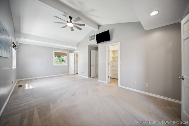 unfurnished bedroom featuring lofted ceiling with beams, a walk in closet, ceiling fan, light colored carpet, and a closet