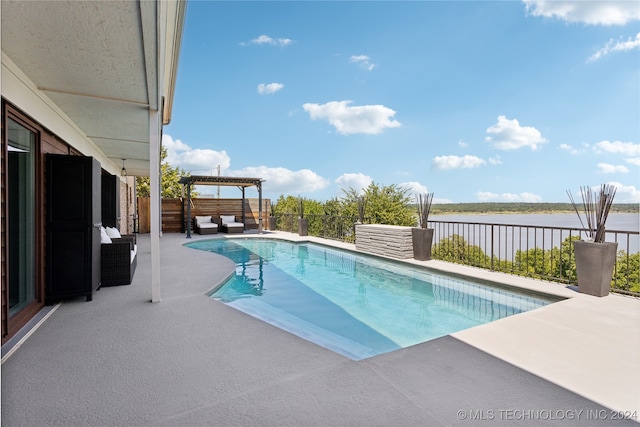 view of pool with a patio and a water view