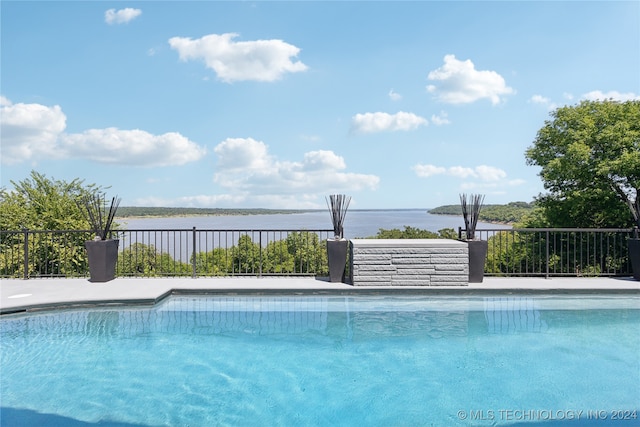 view of swimming pool with a water view