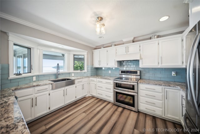 kitchen featuring sink, stainless steel appliances, light stone counters, white cabinets, and ornamental molding