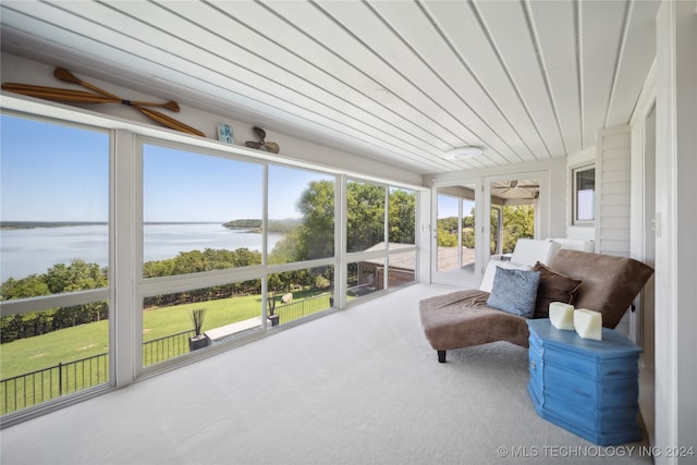 sunroom featuring a water view