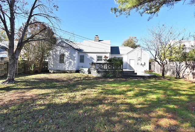 back of property featuring a yard, a deck, and central air condition unit