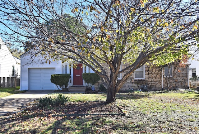 obstructed view of property featuring a garage and a front lawn