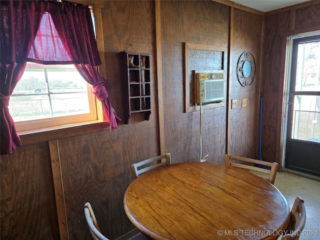 unfurnished dining area featuring cooling unit and wooden walls