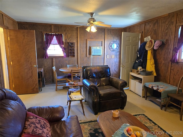 carpeted living room with ceiling fan and wooden walls