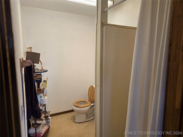 bathroom featuring gas water heater and toilet