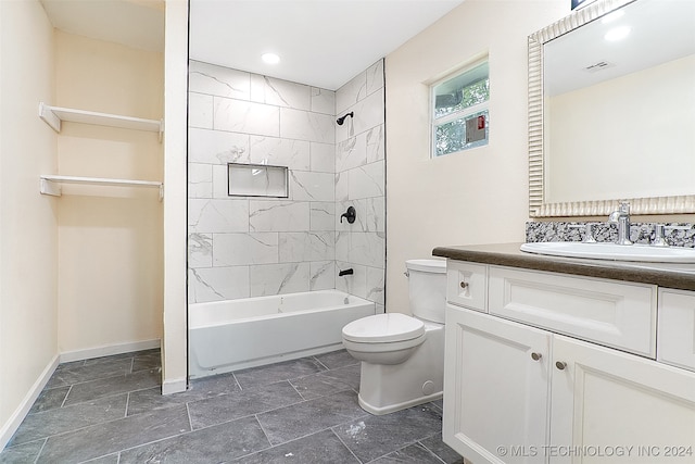 full bathroom featuring tiled shower / bath combo, toilet, and vanity