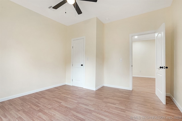 empty room with ceiling fan and light hardwood / wood-style floors