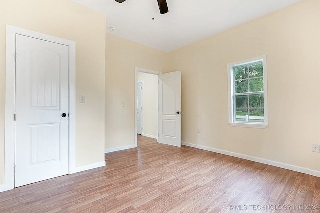 unfurnished bedroom featuring ceiling fan, a closet, and light hardwood / wood-style flooring