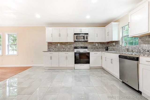 kitchen with plenty of natural light, white cabinets, and stainless steel appliances