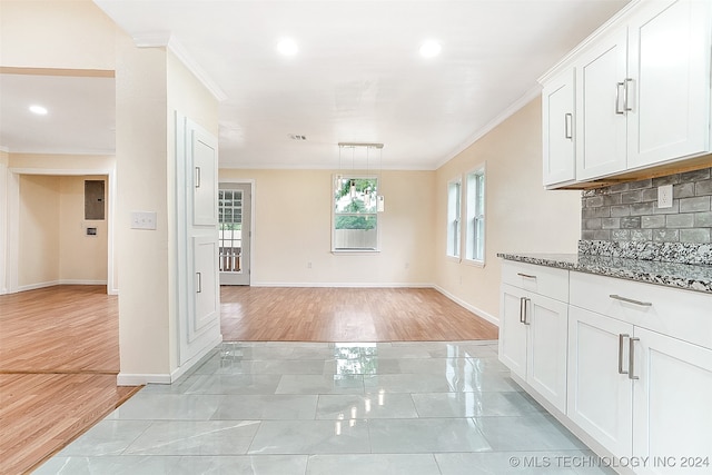 kitchen with a wealth of natural light, white cabinets, and light wood-type flooring