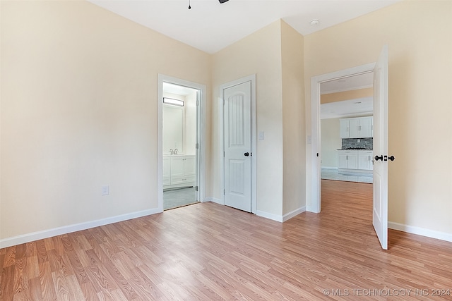 unfurnished bedroom with ceiling fan, light hardwood / wood-style floors, and ensuite bath