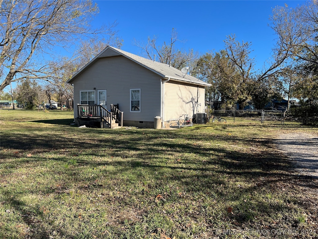 view of side of home with cooling unit and a yard