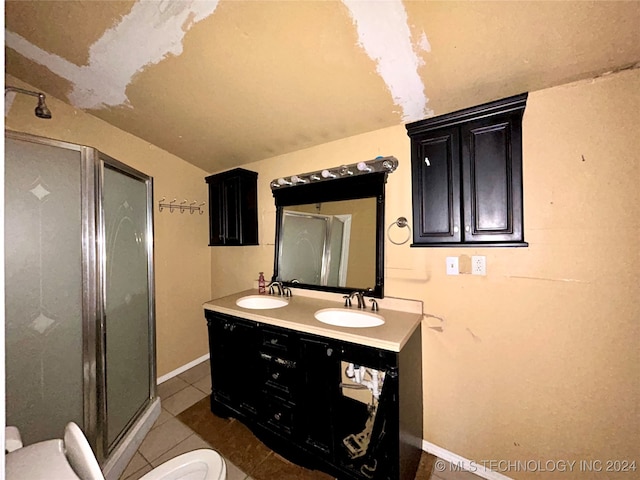 bathroom with an enclosed shower, vanity, vaulted ceiling, tile patterned flooring, and toilet